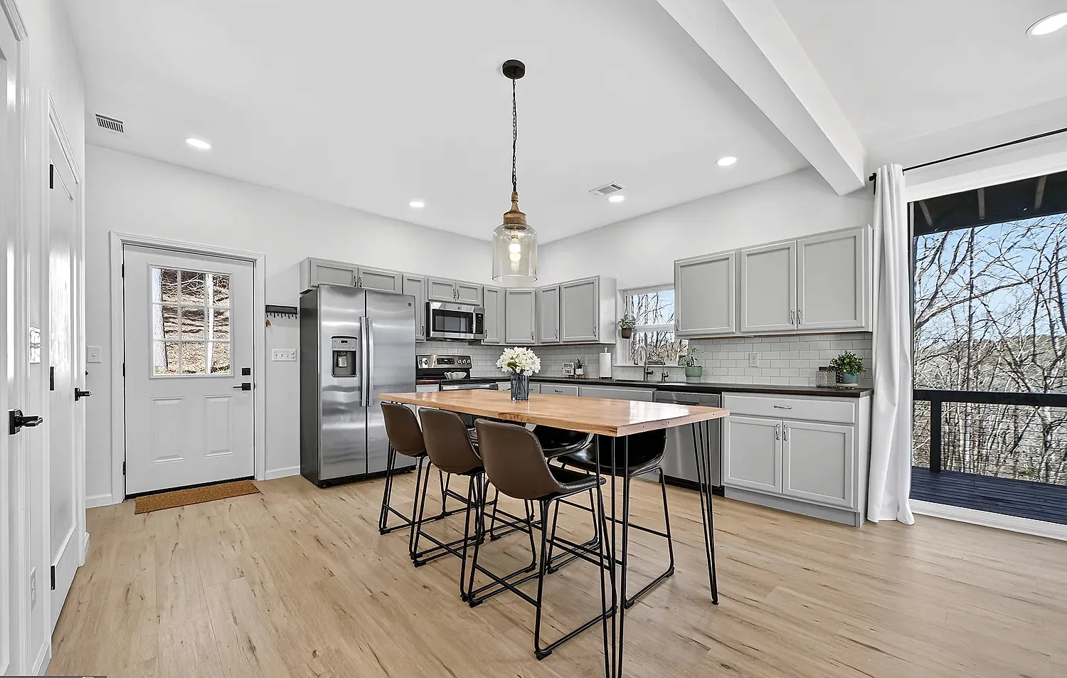 Open gray kitchen with a central wood-topped island
